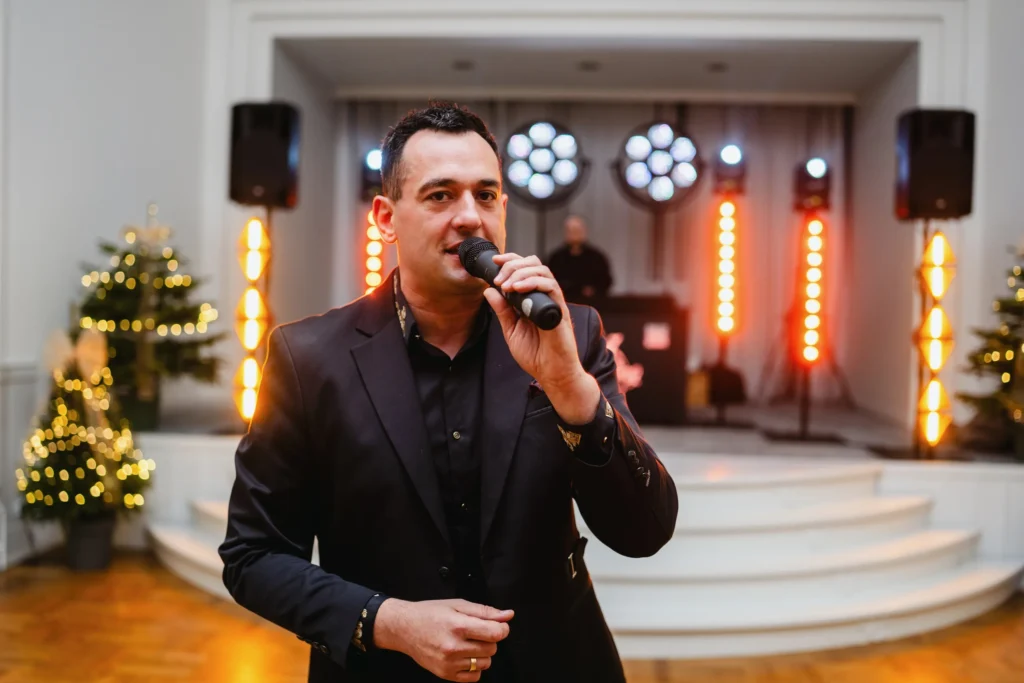 Wodzirej DJ Disco King z mikrofonem przed sceną